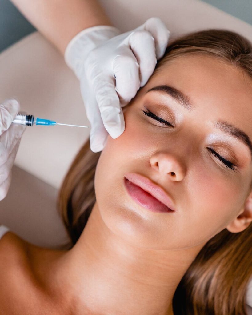 Woman receiving a cosmetic injection on her cheek.