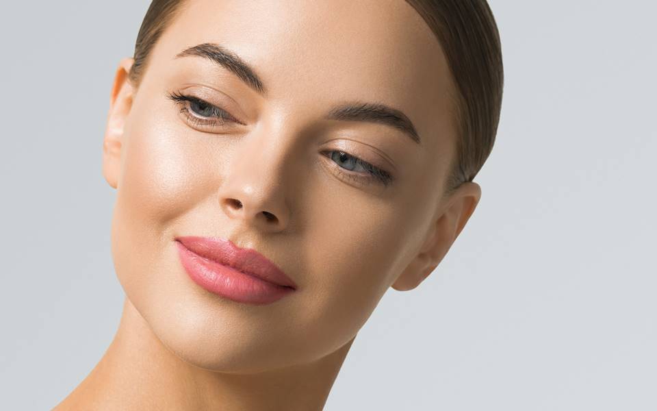 Close-up of a woman with flawless skin and subtle makeup.