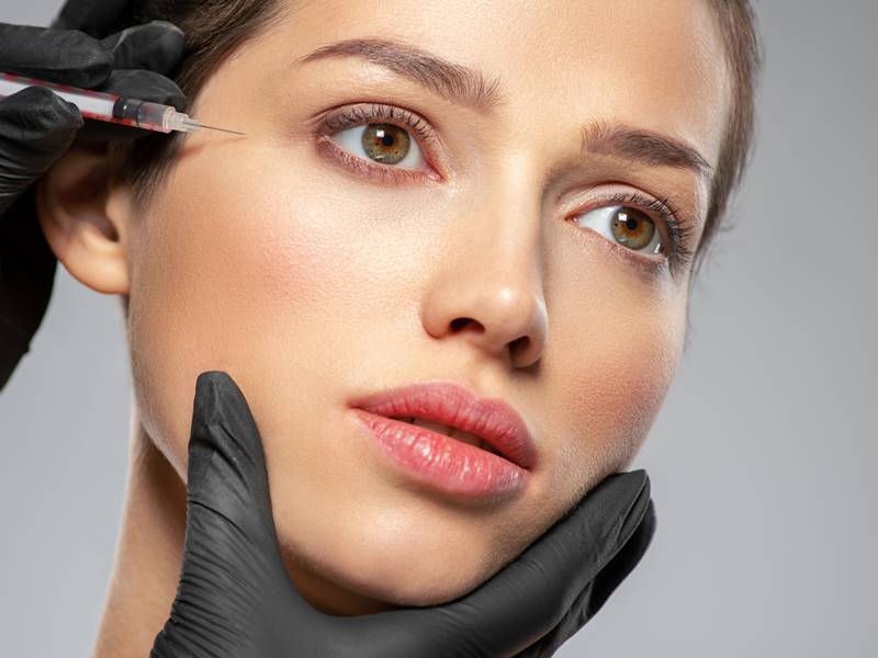 Close-up of a woman applying makeup with a brush.