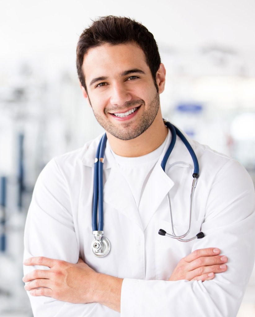 Smiling male doctor with stethoscope in medical setting.