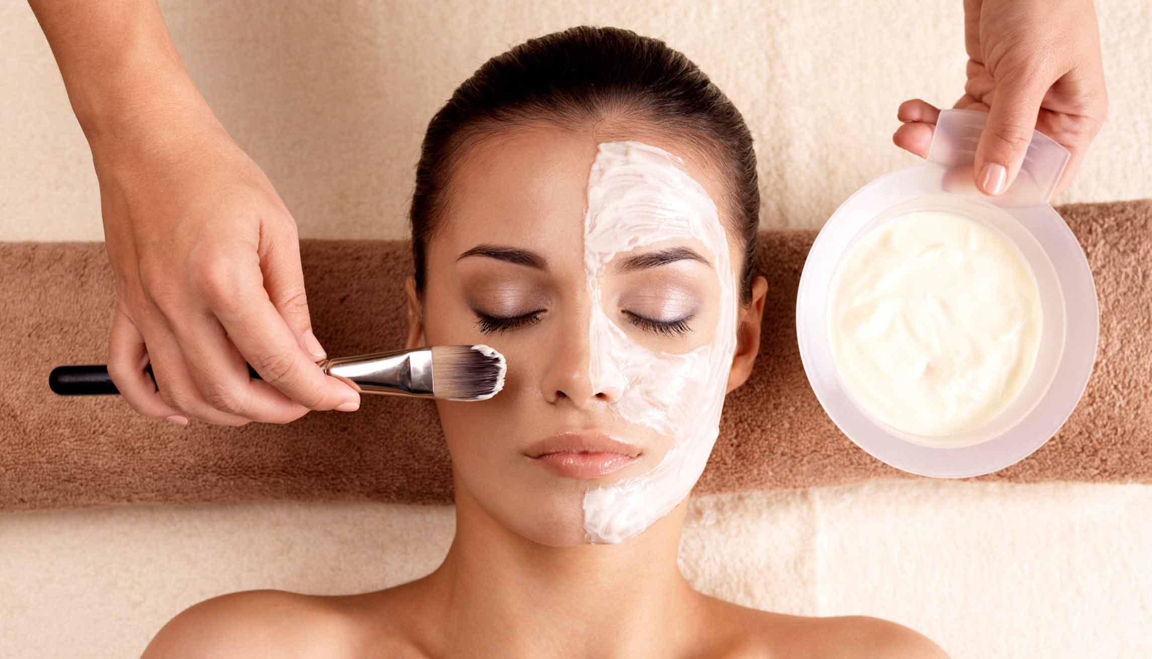 Woman receiving a facial mask treatment at a spa.