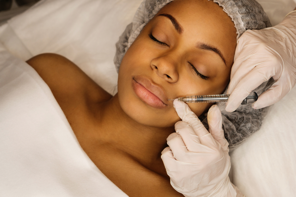 Woman receiving a cosmetic injection in her face at a clinic.